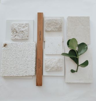 Aesthetic arrangement of stone textures with wooden ruler and greenery.
