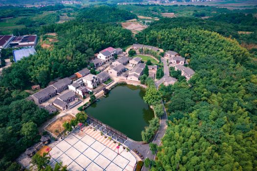 Aerial view of a serene village with lake and lush greenery in Jiangxi, China.