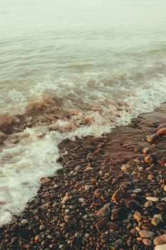 Tranquil pebble beach in Batumi, Georgia with gentle waves at sunset, perfect for relaxation and nature lovers.