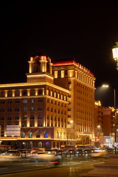 Bright lights illuminate an elegant building in Harbin at night.