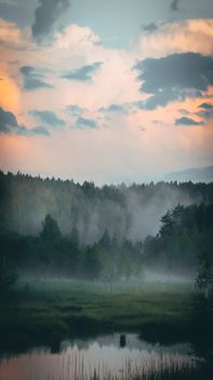 Breathtaking view of a misty forest at dawn with a serene river reflecting the sky, perfect for nature lovers.