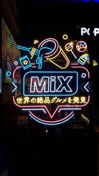 Bright neon sign displaying colorful graphics on a Kuala Lumpur street. Night atmosphere with energetic vibes.