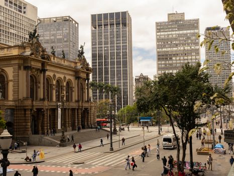 Vibrant cityscape featuring historic and modern buildings at a busy urban intersection.