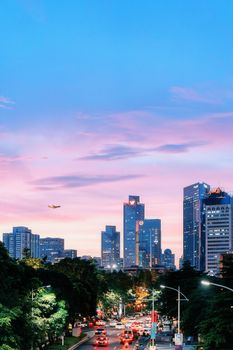 Vibrant Guangzhou cityscape at twilight with illuminated skyscrapers and bustling traffic, capturing urban life.