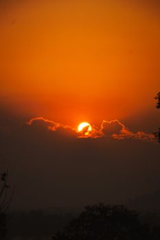 Captivating sunset scene with vibrant orange hues and silhouetted clouds.