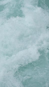 Close-up of white water foam and movement in a natural setting, showcasing texture and color.