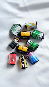 A vibrant assortment of analog film rolls on a white background, showcasing variety and nostalgia.
