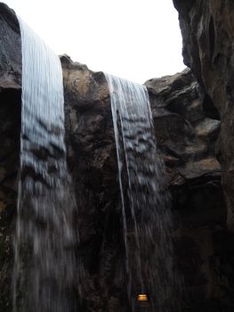 A stunning view of a waterfall cascading between rocky cliffs in Hong Kong.