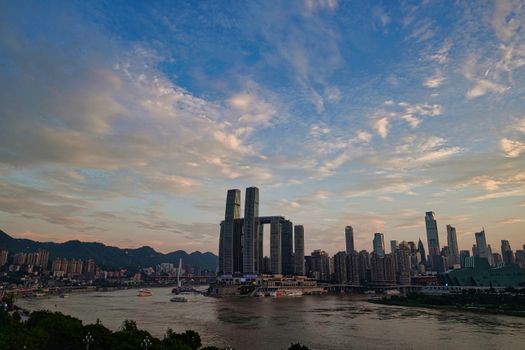 Stunning view of Chongqing's skyline with skyscrapers and Yangtze River at sunset.