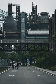 View of an industrial area with smokestacks and people walking in Beijing, China.