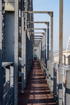 A cyclist riding across an iron bridge in Harbin, showcasing intricate metal architecture.