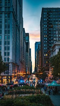 A bustling downtown Chicago street at sunset showcasing historic architecture and lively atmosphere.