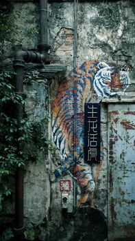 Vibrant tiger mural on rustic wall in Kuala Lumpur, Malaysia highlighting urban art.