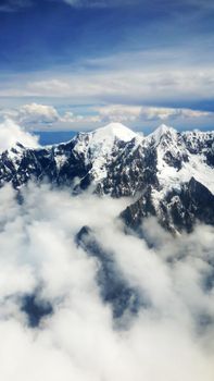 Stunning aerial view of snow-capped Andes mountains with clouds in La Paz, Bolivia.