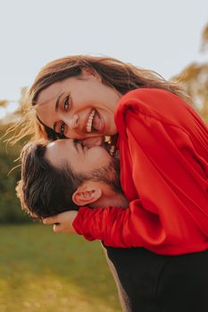 Joyful couple in a loving embrace on a sunny day in an İstanbul park.