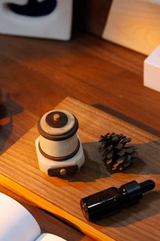 Aesthetic desk setup features a wooden coffee grinder, pine cone, and a small bottle, creating a cozy vibe.