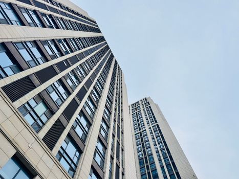 Upward view of contemporary skyscrapers in Tianjin, showcasing modern architectural design.