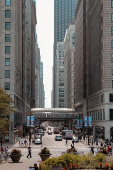 A bustling city street scene features high-rise buildings and people walking.