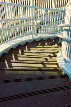 Curved white spiral staircase with dramatic shadows in Taiwan. Perfect for architectural themes.
