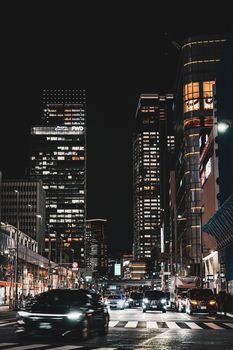 Vibrant night scene of Tokyo's bustling streets filled with skyscrapers and traffic lights.