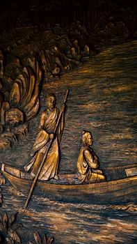 Detailed wooden carving depicting an ancient boat scene, showcasing traditional Vietnamese art.