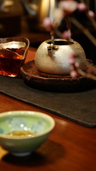 Elegant Chinese tea set with pot and cups on wooden table, creating a warm, inviting atmosphere.