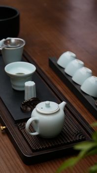 Elegant arrangement of a traditional Chinese tea set on a wooden table with serene atmosphere.
