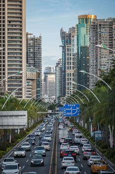 Aerial view of busy traffic on urban streets surrounded by skyscrapers in Xiamen, China.