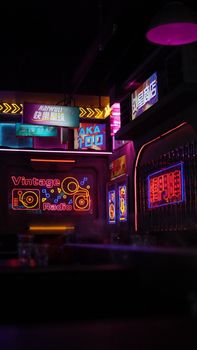 Vibrant neon lights and signs in a vintage-themed bar with retro aesthetics creating a moody atmosphere.